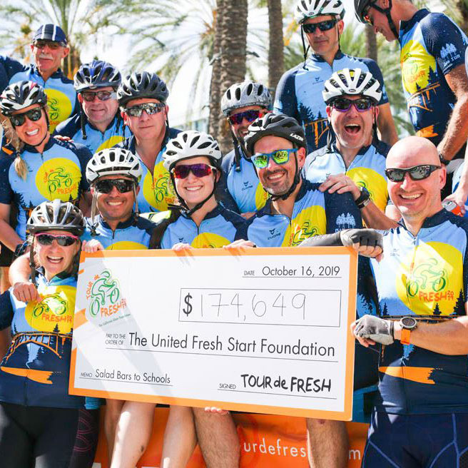 Group of Sakata cyclists holding donation check
